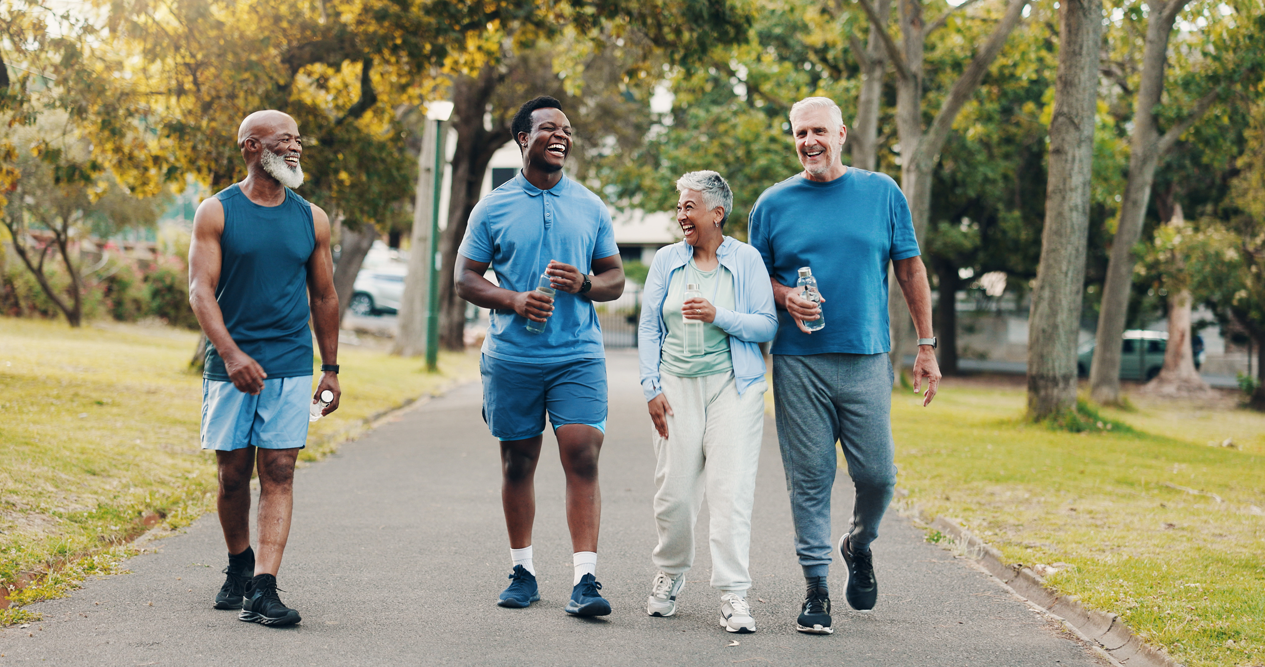 Four friends enjoying a walk together in a sunny park.